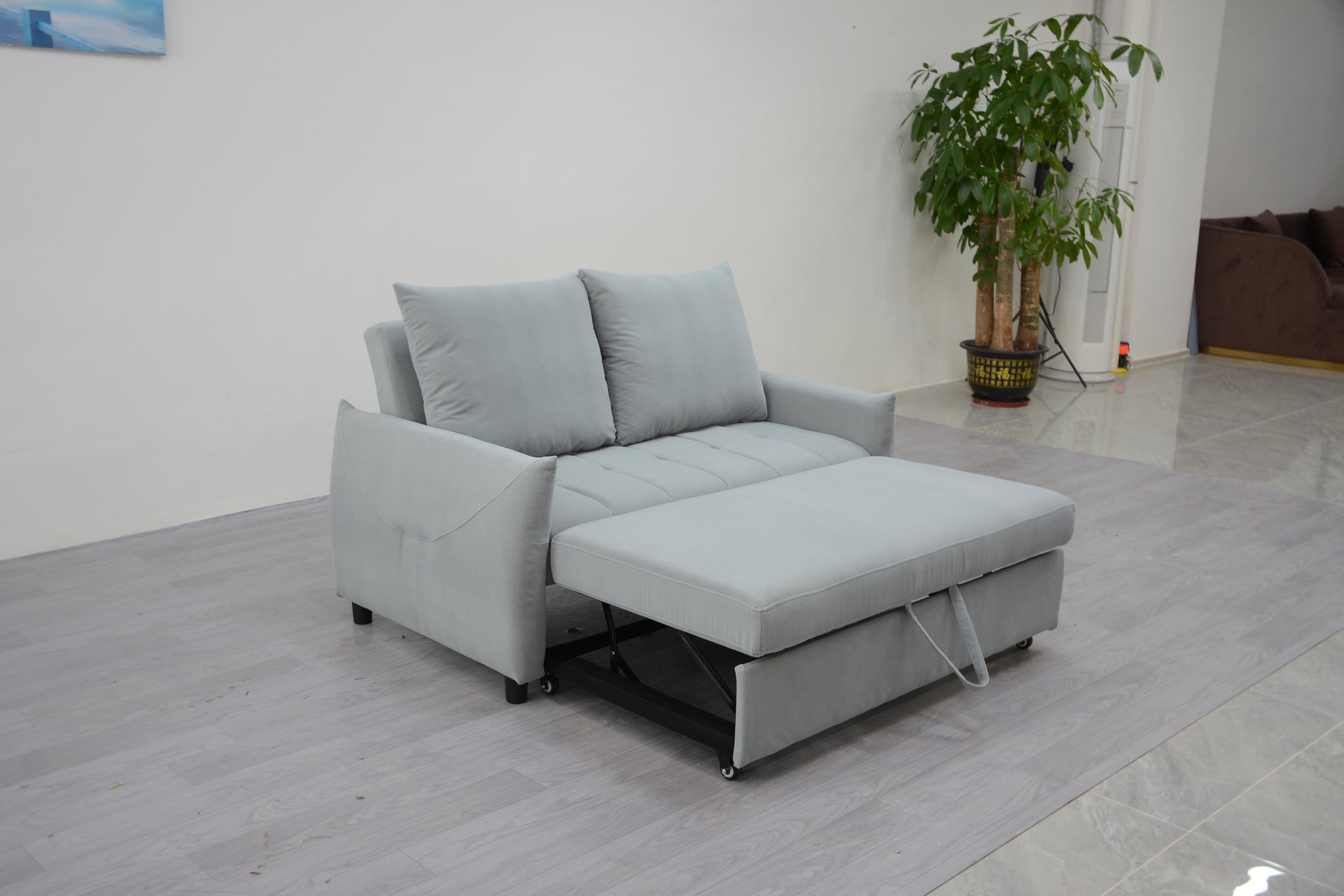 Light grey fabric sofa bed with storage ottoman extended