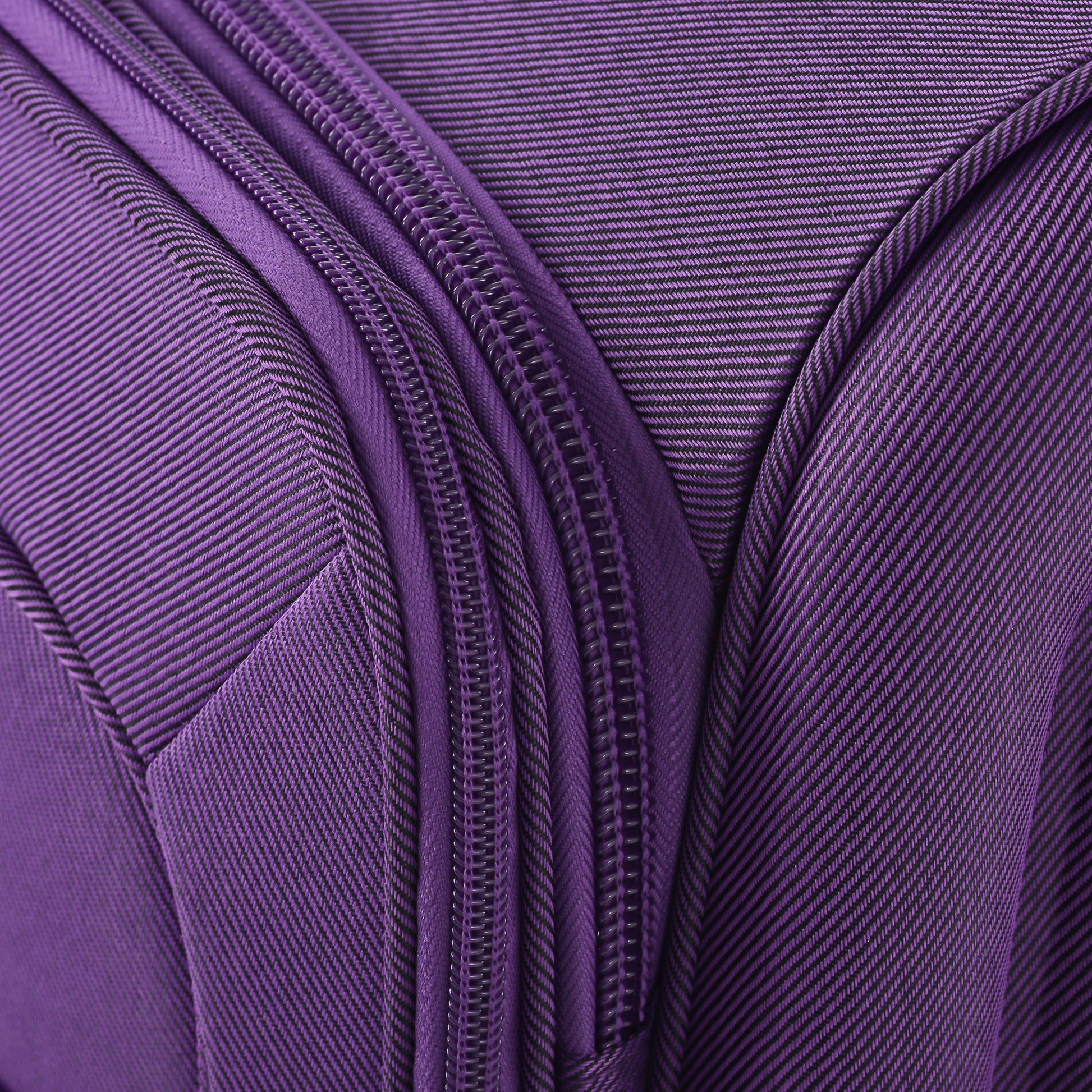 Closeup of a purple fabric suitcase with a textured weave and prominent zipper