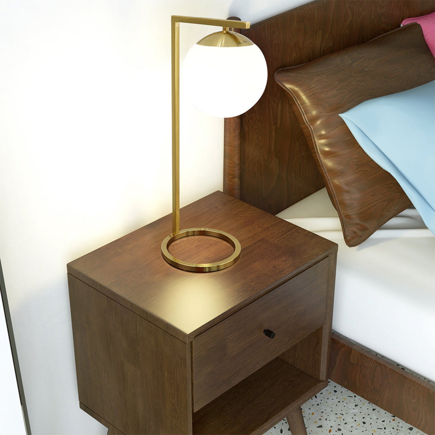 Modern gold desk lamp with white globe shade illuminates a dark wood nightstand