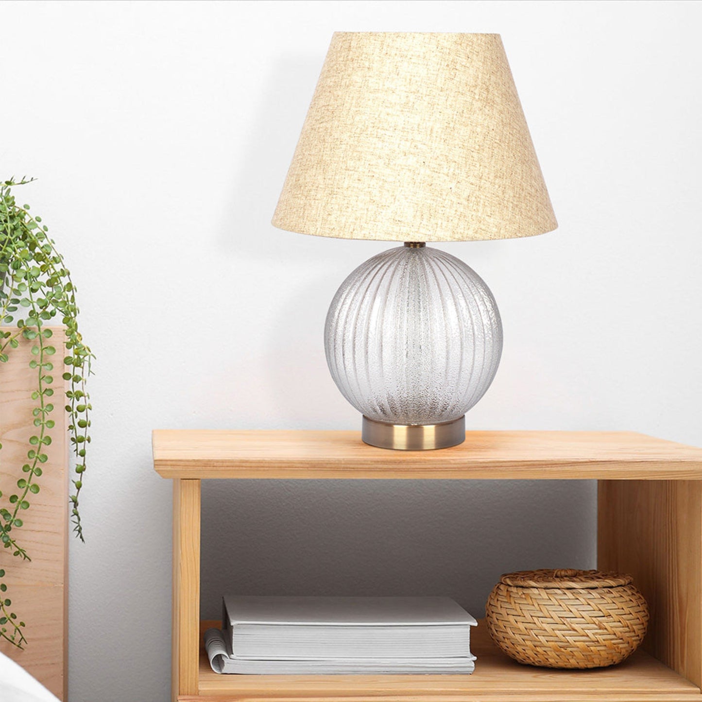 Textured glass bedside lamp with a linen shade and brushed brass base