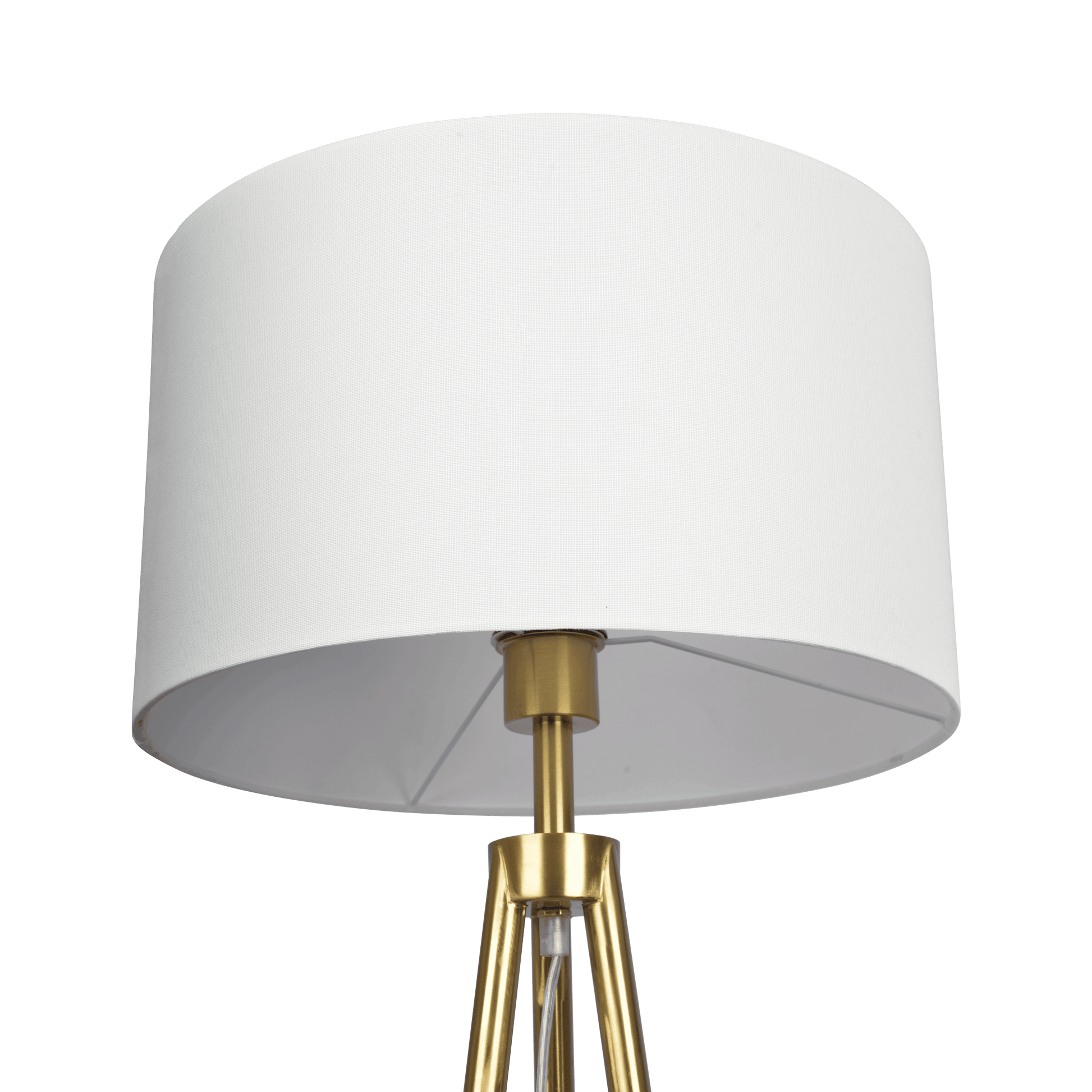 Closeup of a modern brass tripod floor lamp with a white drum shade