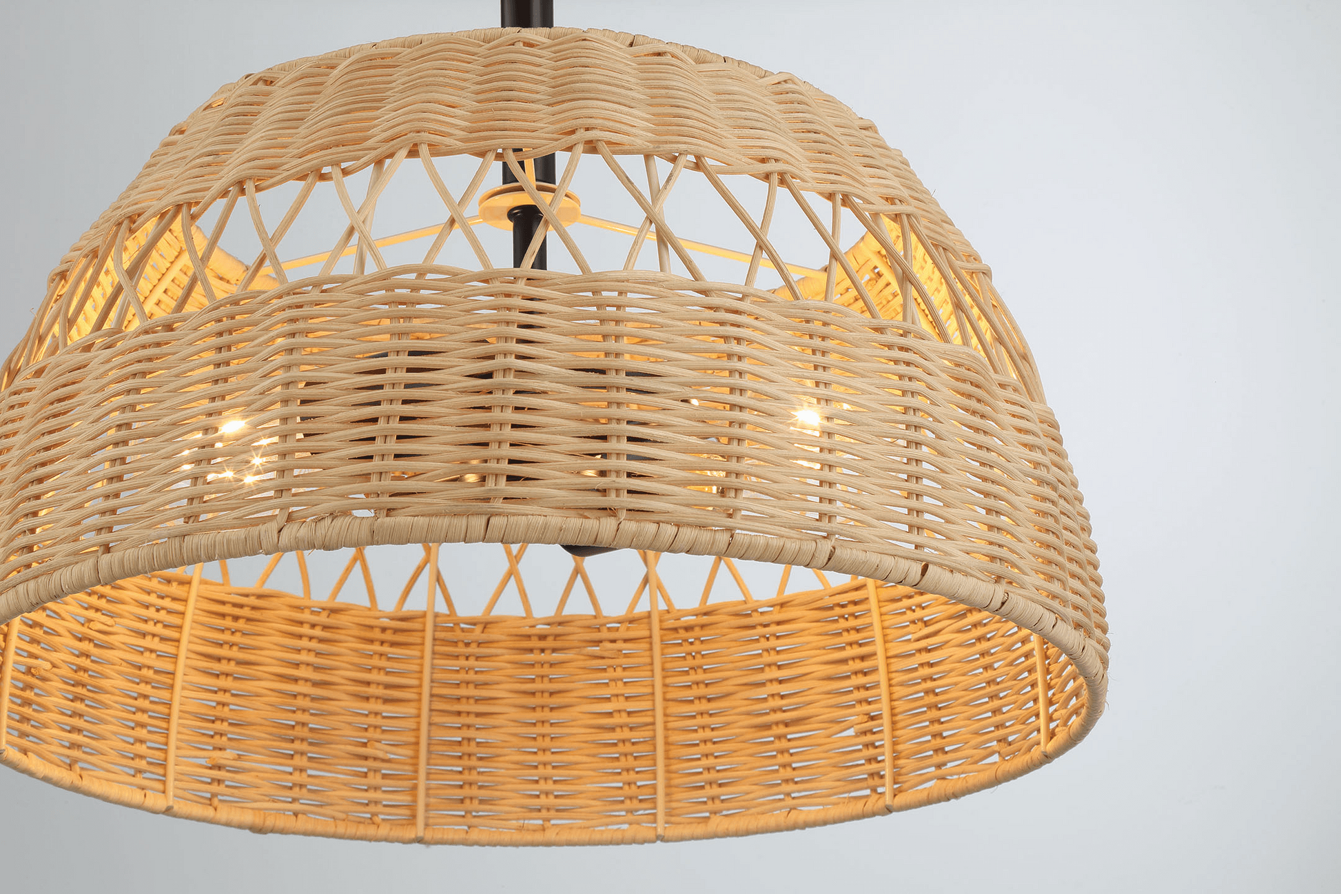 Natural rattan pendant light with a woven dome shade emitting a warm glow