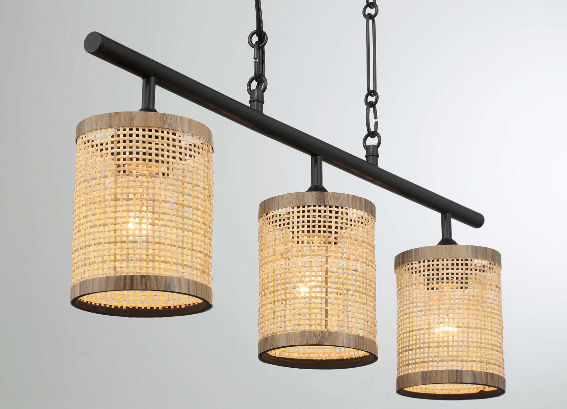 Black linear chandelier with three natural rattan shades and wood accents