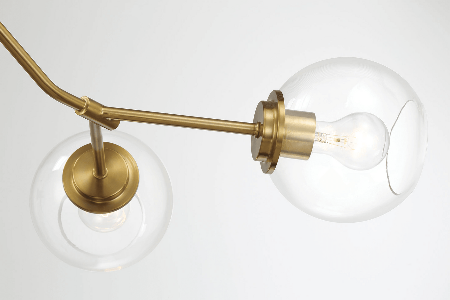 Brass modern chandelier with clear glass globes and visible filament bulbs