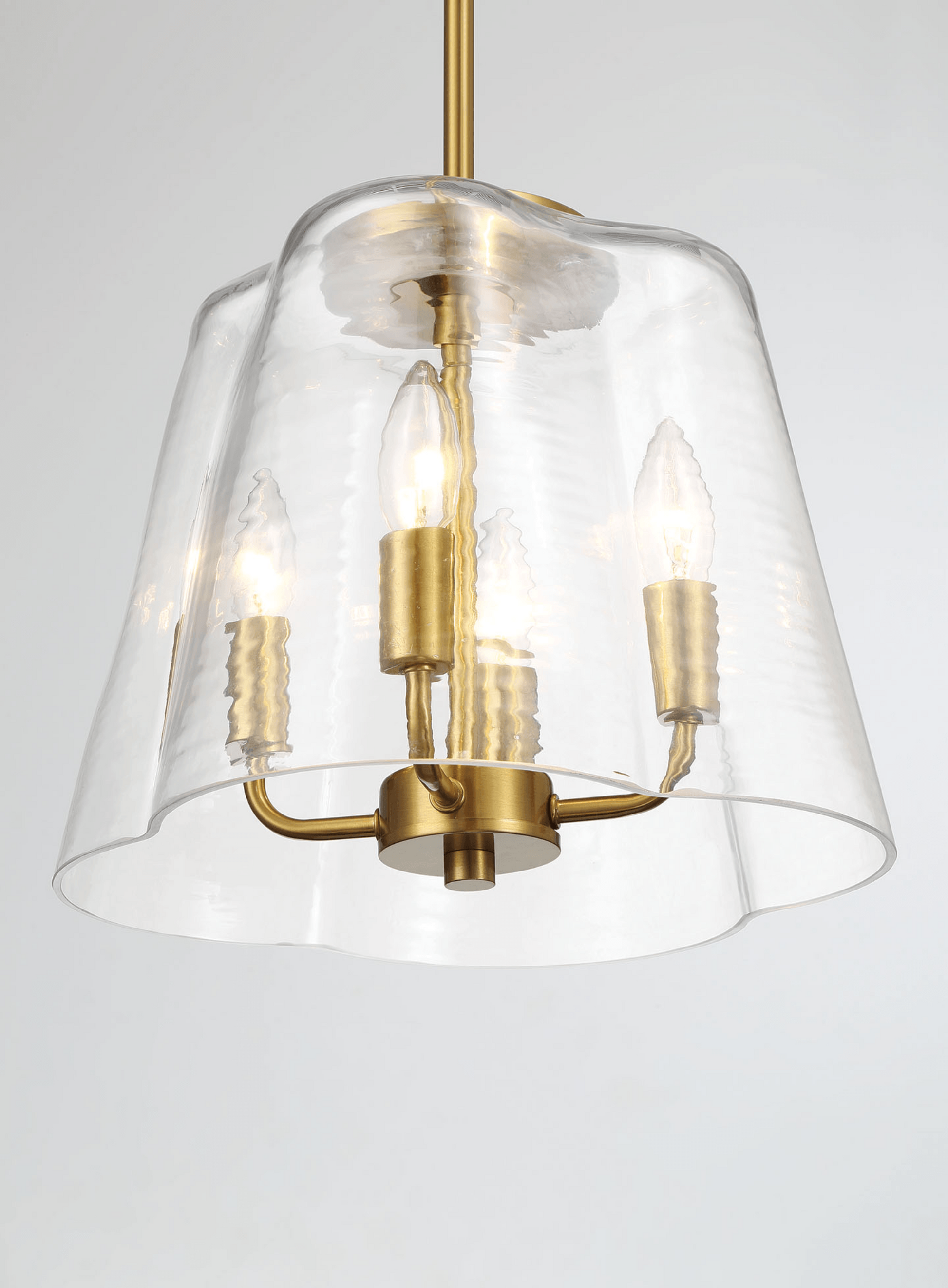 Modern brass pendant light with clear wavy glass shade and exposed bulbs
