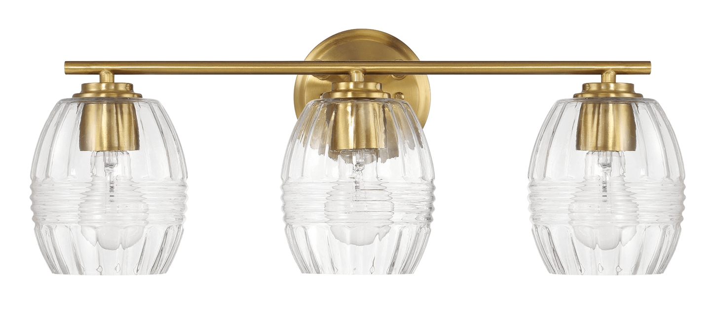 A modern brass vanity light with three ribbed glass shades for bathroom lighting