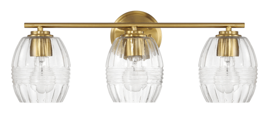 A modern brass vanity light with three ribbed glass shades for bathroom lighting