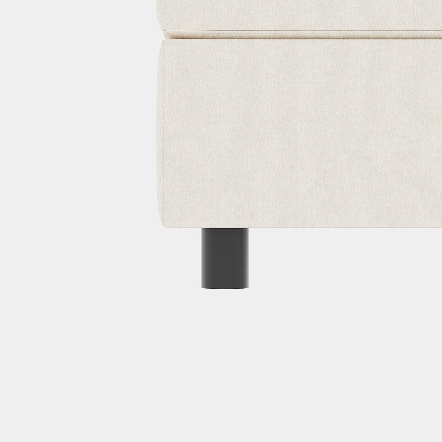 Closeup of a beige linen couch arm with a dark grey cylindrical leg