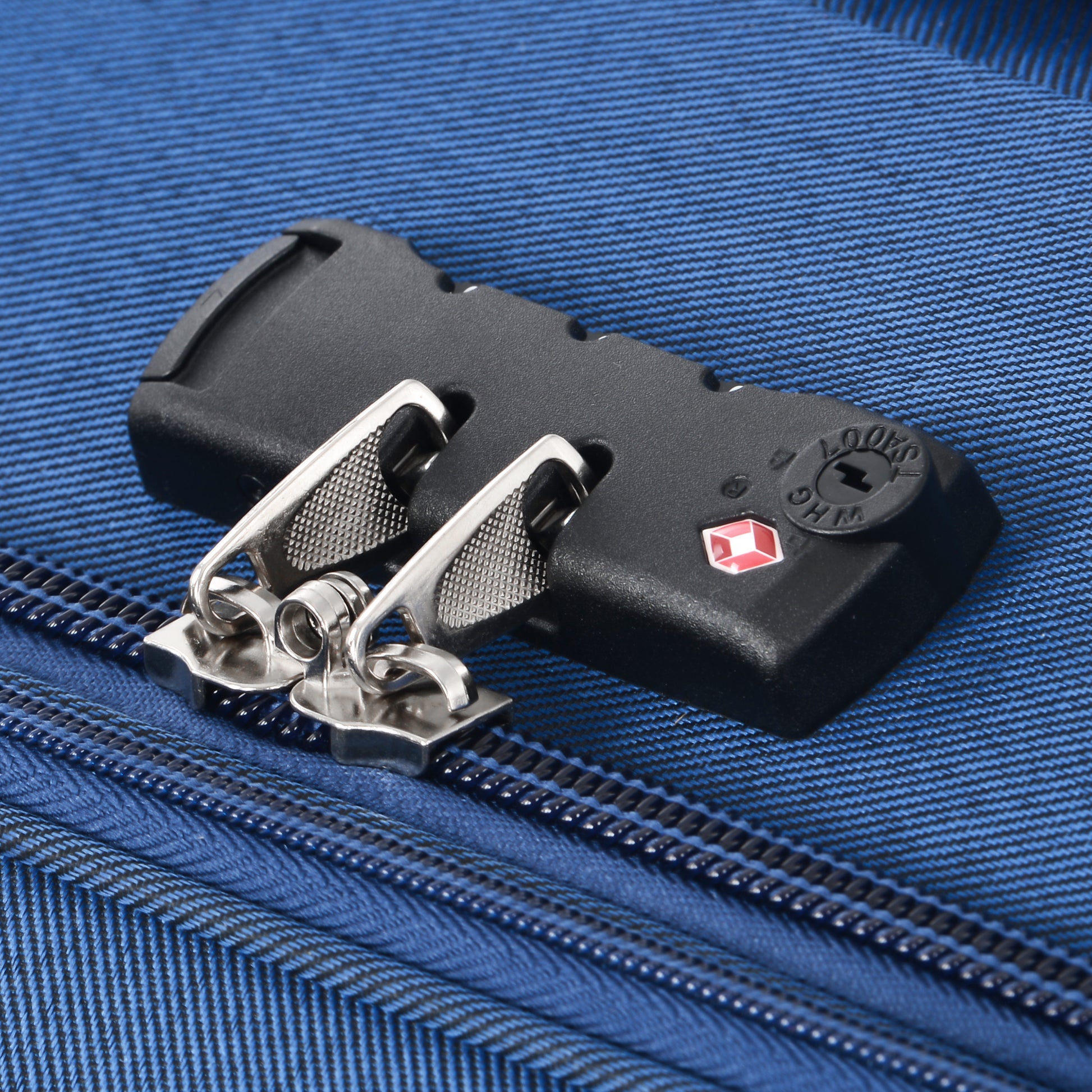 TSA lock on a blue luggage zipper with chrome pull tabs