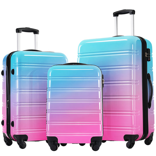 Three hardside suitcases with a blue to pink ombre gradient featuring spinner wheels
