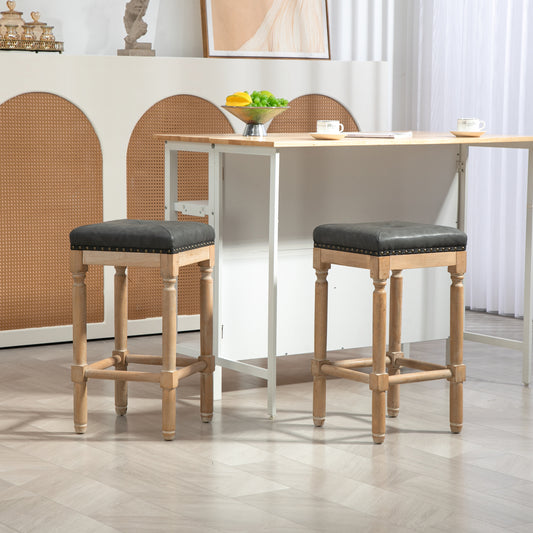 Dark grey tufted bar stool with nailhead trim and wooden legs
