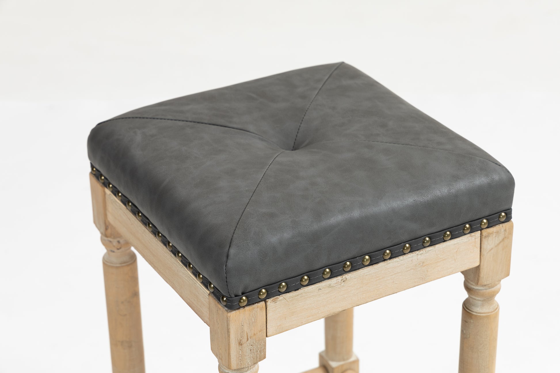 Square grey faux leather bar stool with tufted top and brass nailhead trim