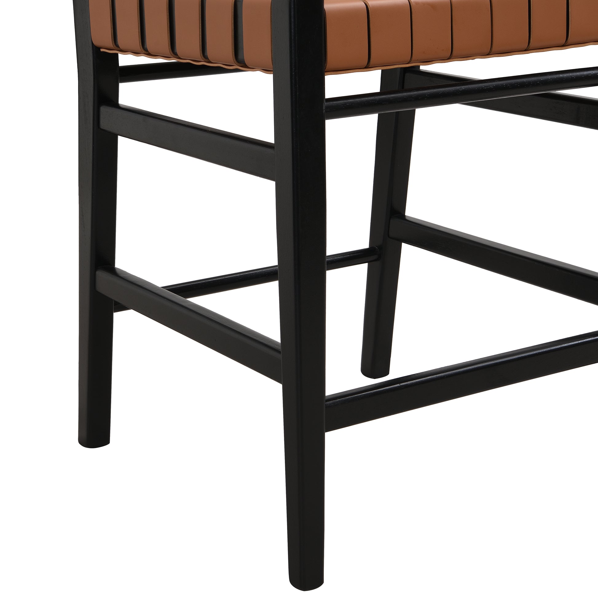 Closeup of a modern chair featuring a black wood frame and tan leather straps for seating