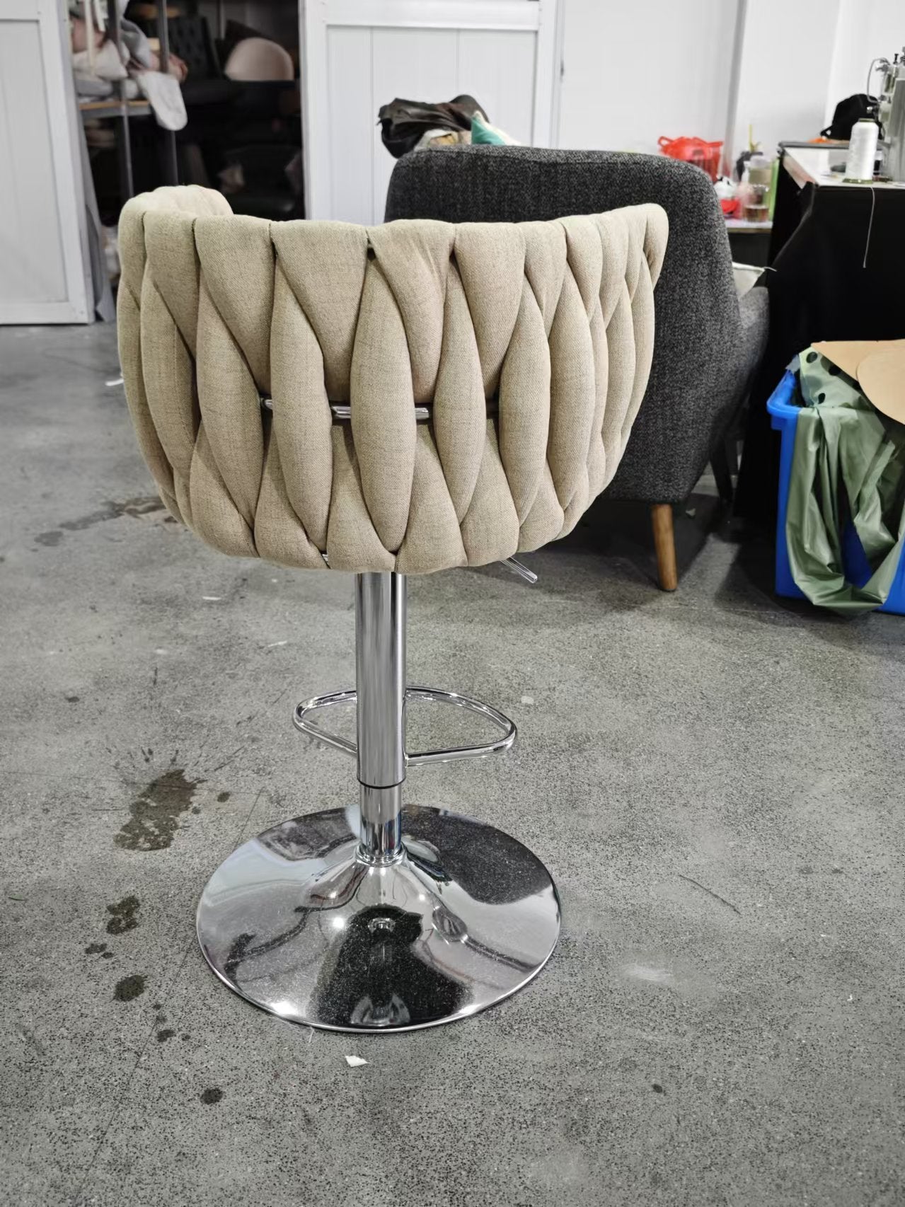 Beige tufted upholstered bar stool with chrome base and footrest