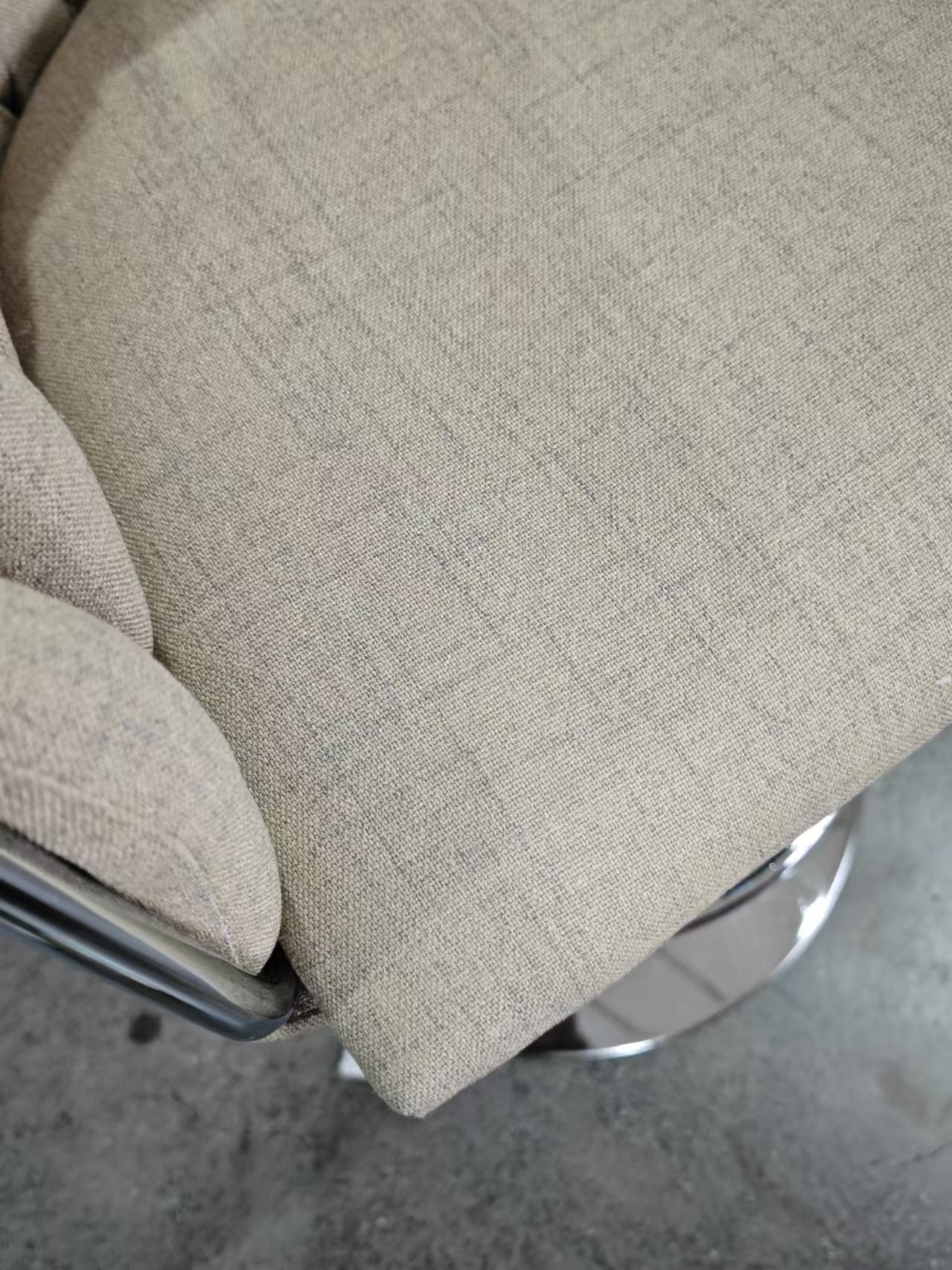 Closeup of beige textured fabric on a modern swivel chair seat