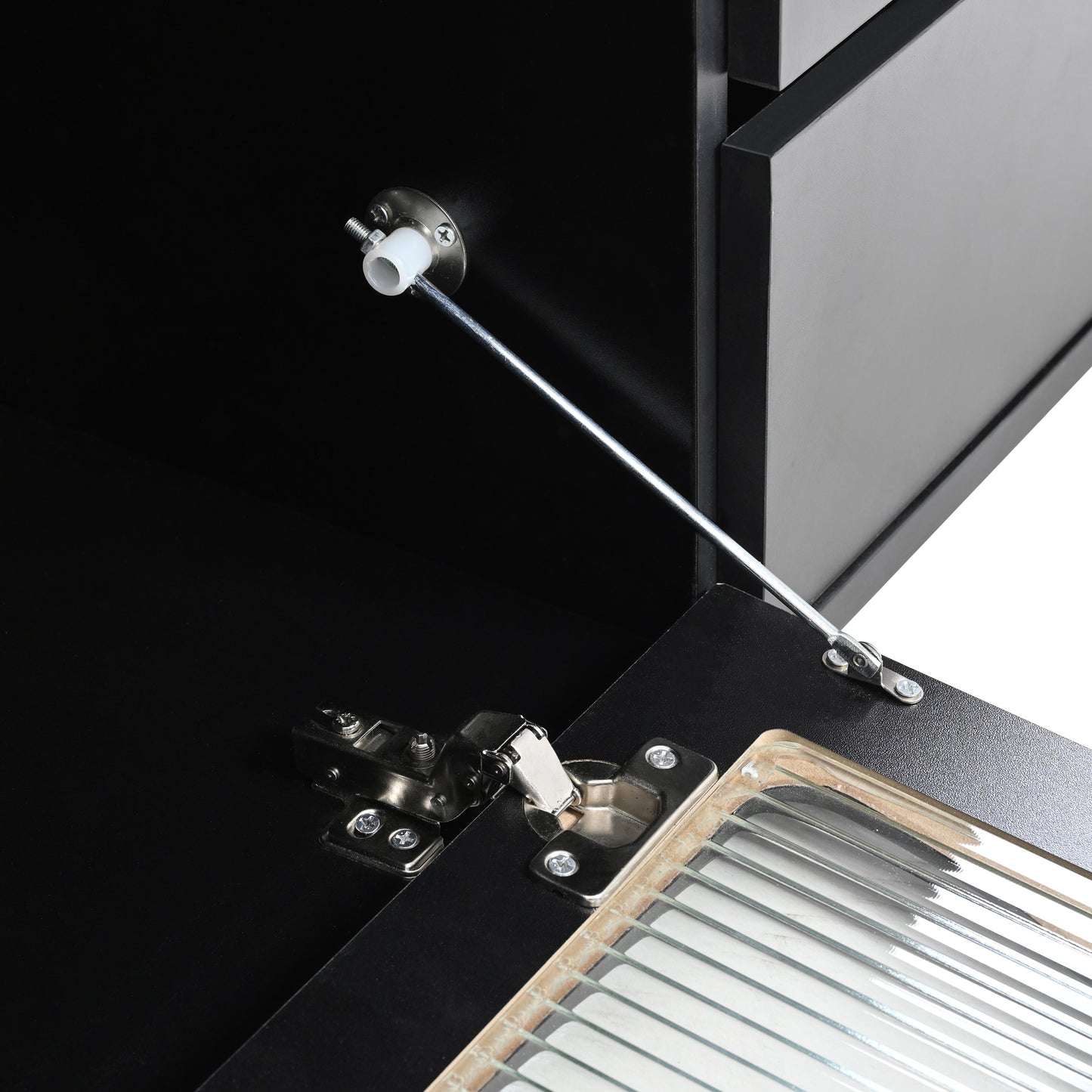 Closeup of black cabinet hinge and gas strut support mechanism