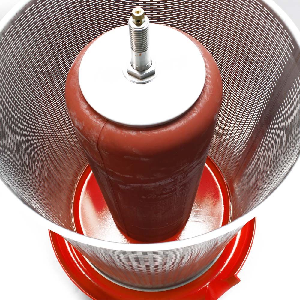 Stainless steel hydraulic press plunger and red rubber bladder inside a perforated stainless steel basket