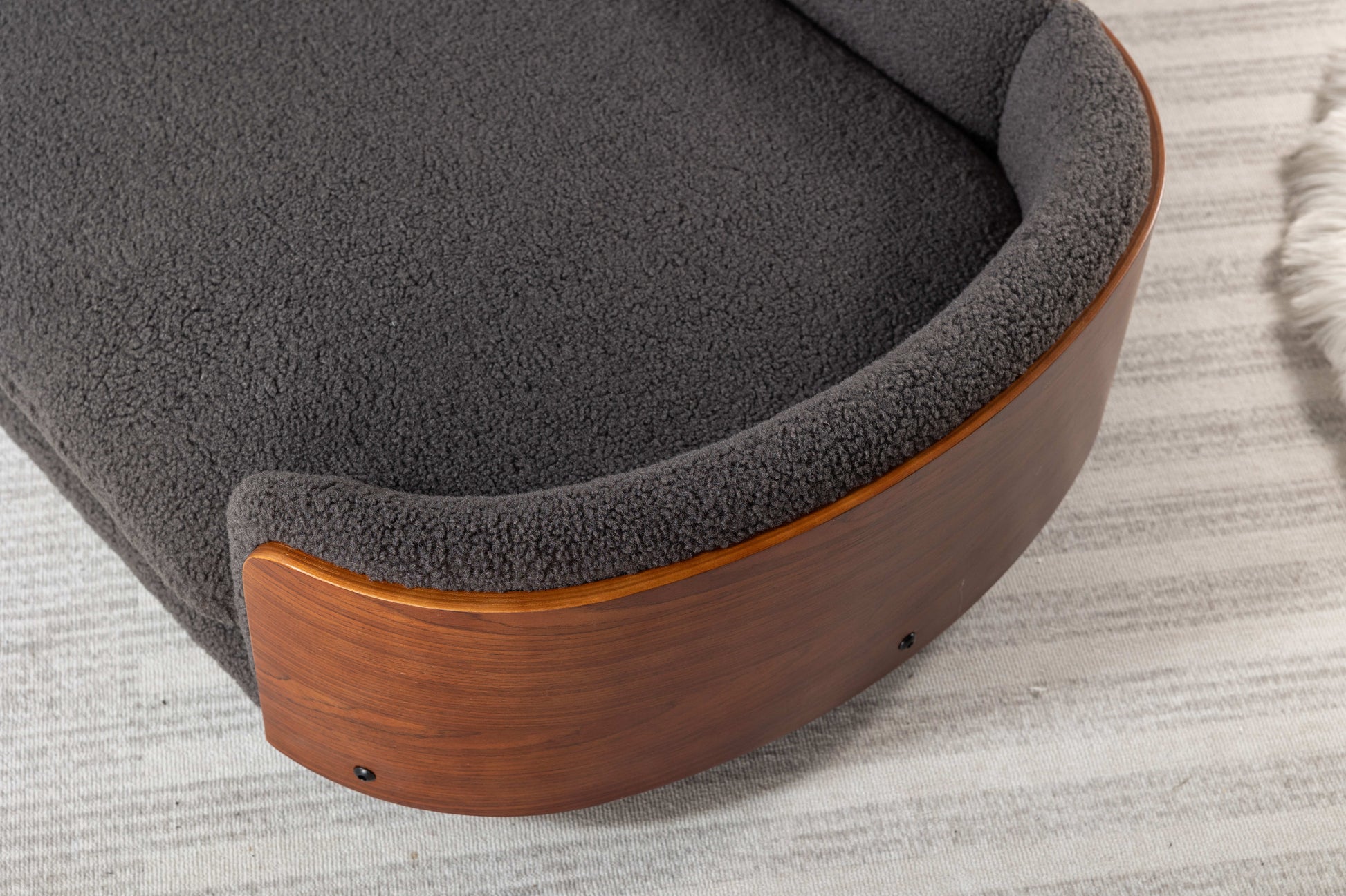 Dark grey plush dog bed with curved wooden base and soft sherpa lining