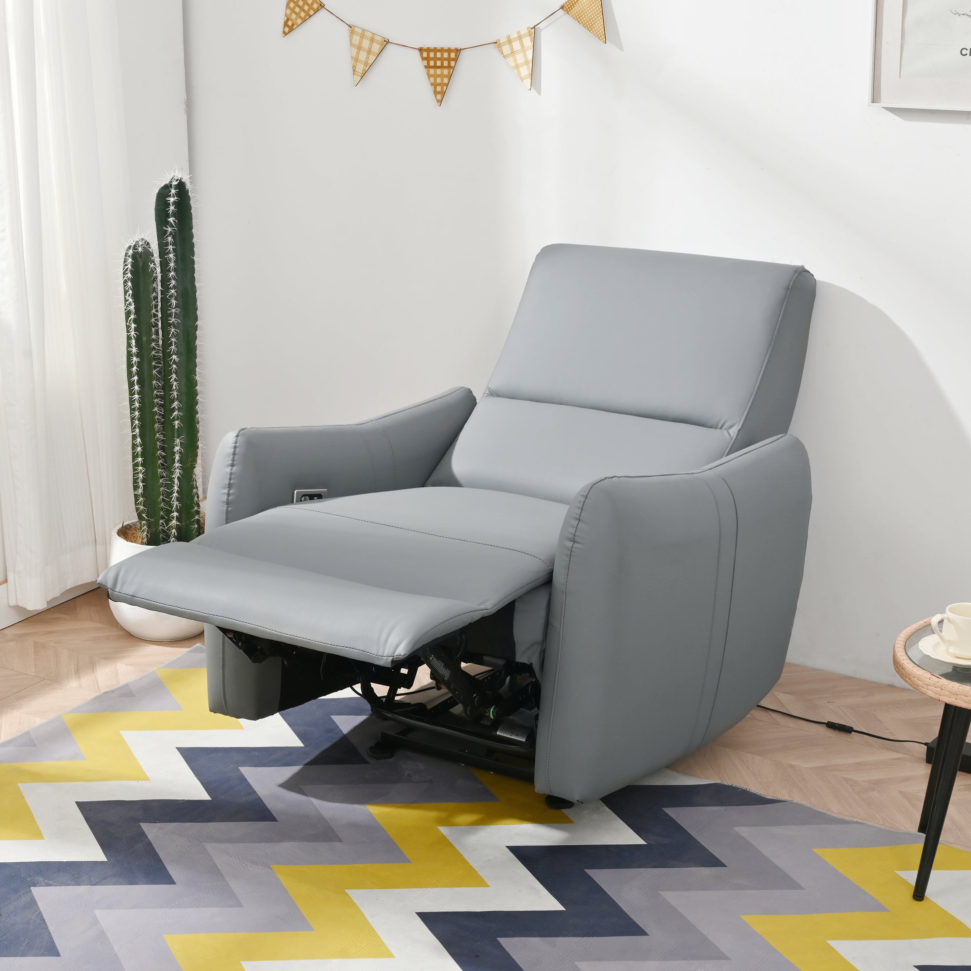 Gray leather power recliner chair with extended footrest and adjustable back for ultimate comfort