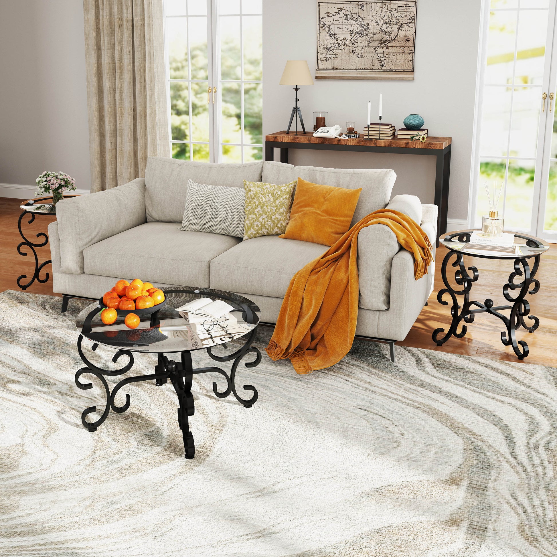 Round glass coffee table with ornate black metal base and oranges