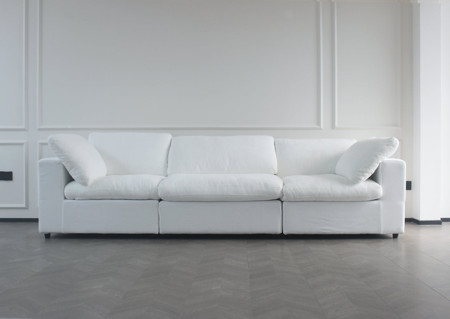 Plush white fabric threeseater sofa with deep cushions and removable slipcovers