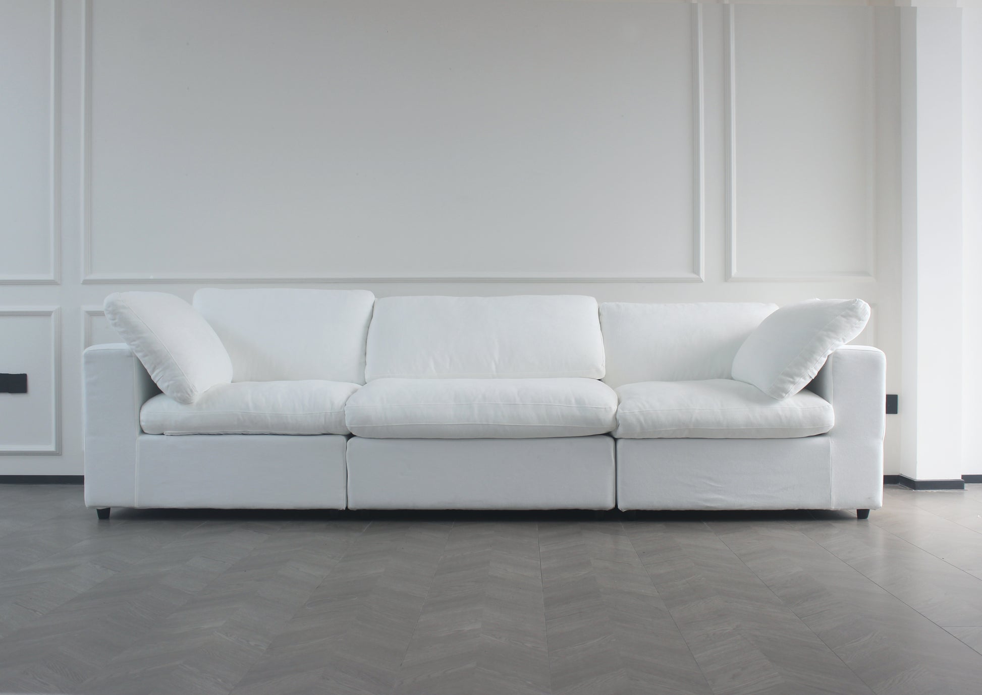 Plush white fabric threeseater sofa with deep cushions and removable slipcovers