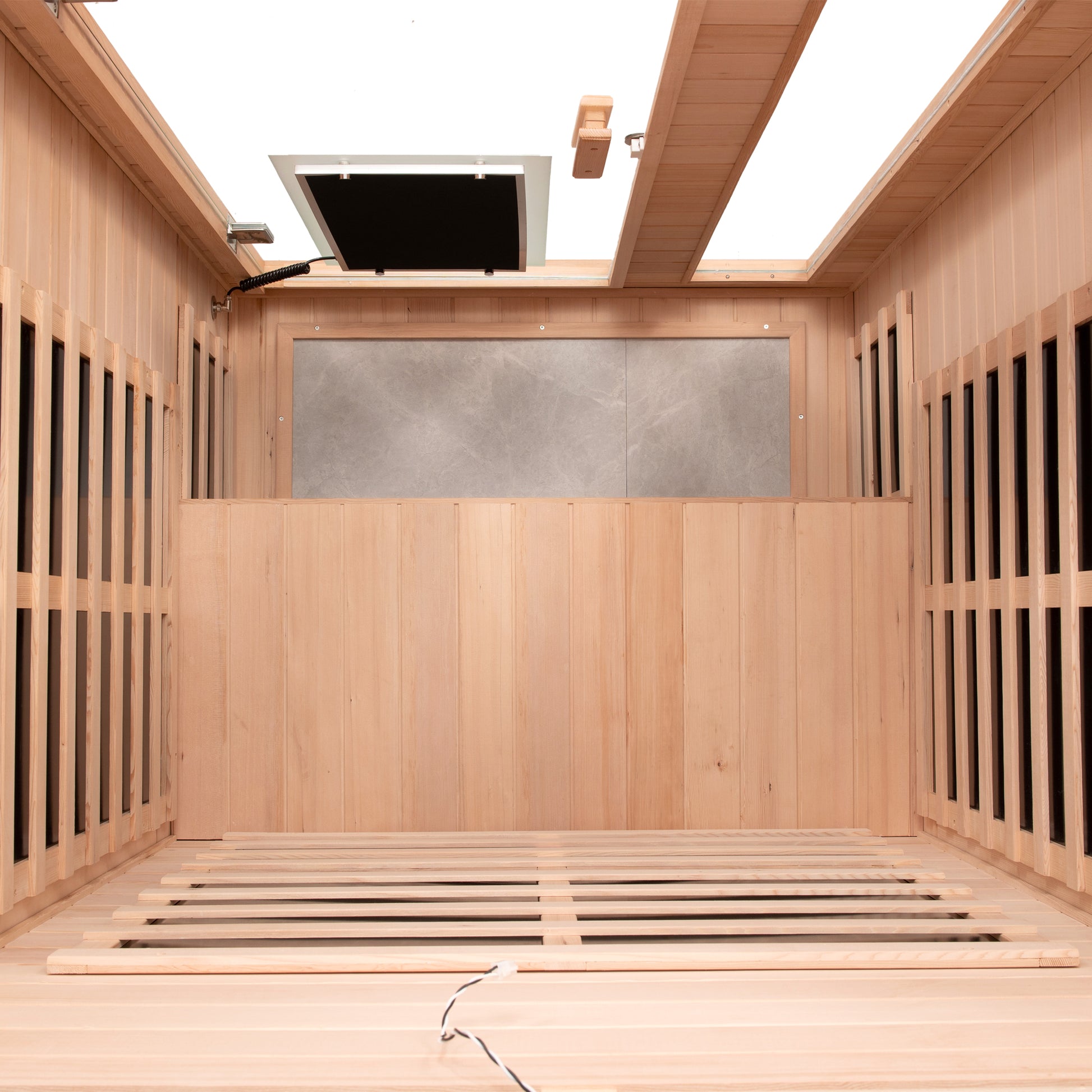 Interior view of a modern infrared sauna with wooden panels and slatted floor