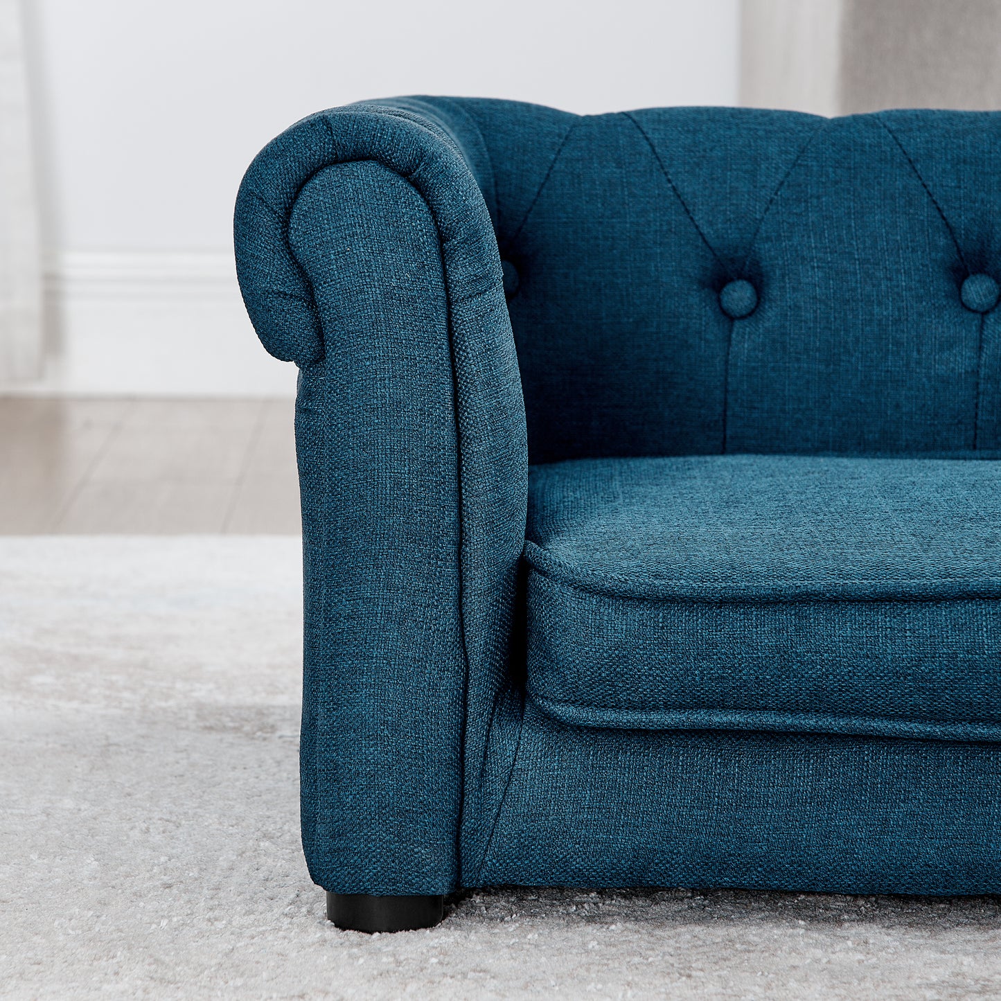 Deep blue fabric chesterfield armchair armrest detail tufted back and seat cushion