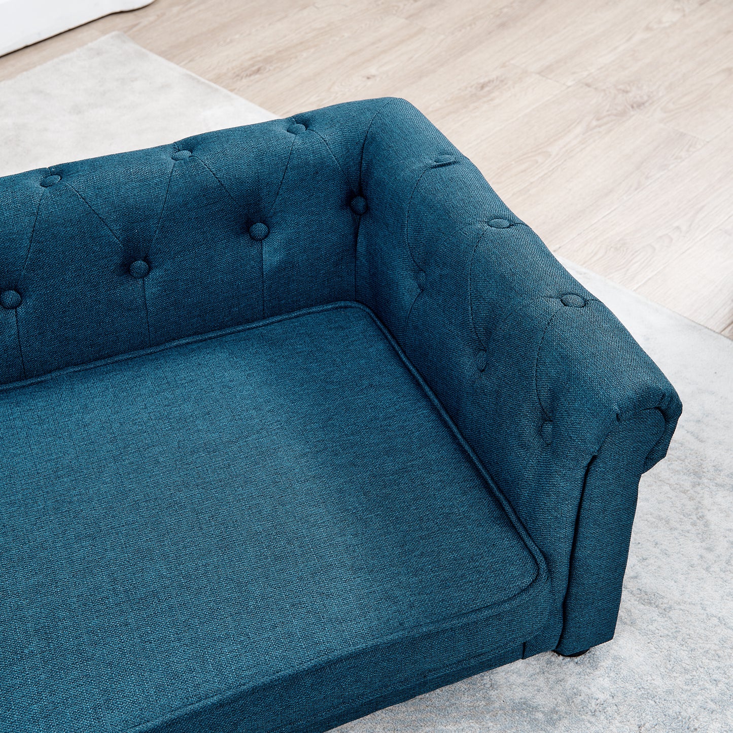 Deep teal fabric chesterfield sofa upholstered with button tufting and plush seat cushions for comfort