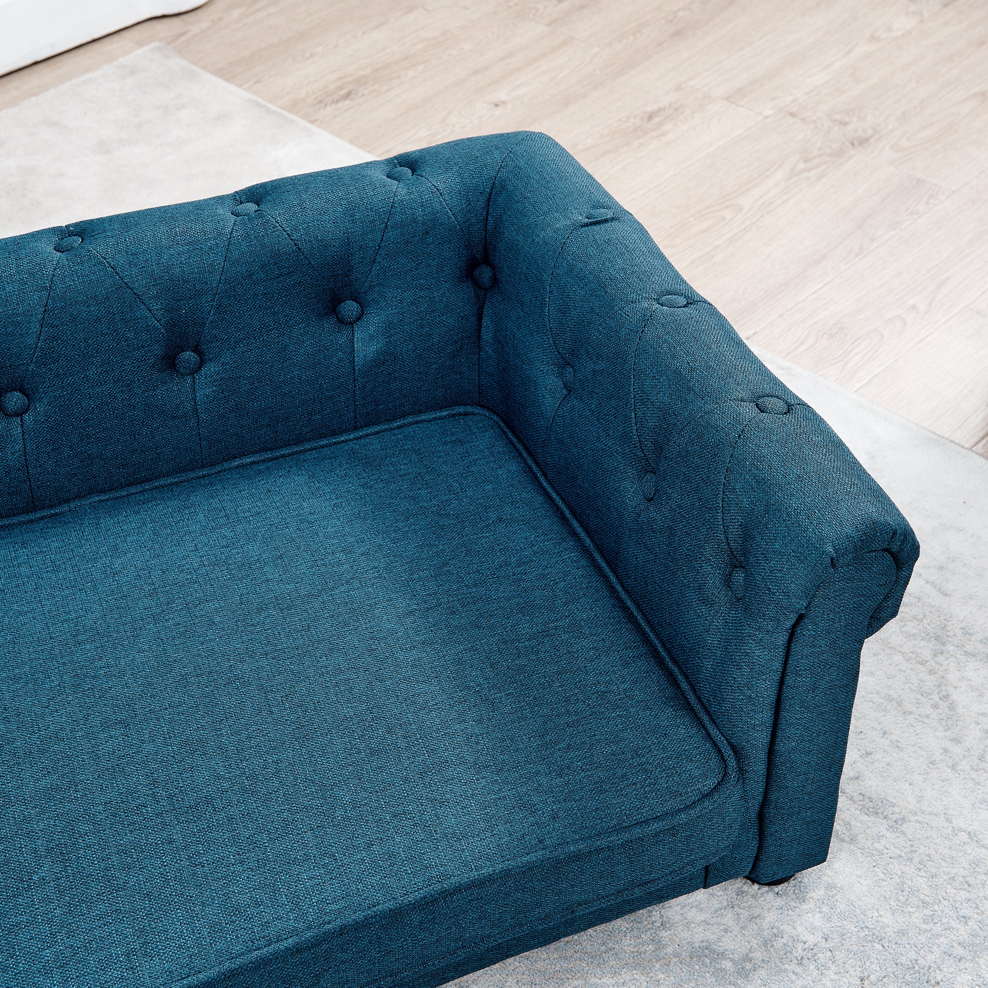 Deep teal fabric chesterfield sofa upholstered with button tufting and plush seat cushions for comfort