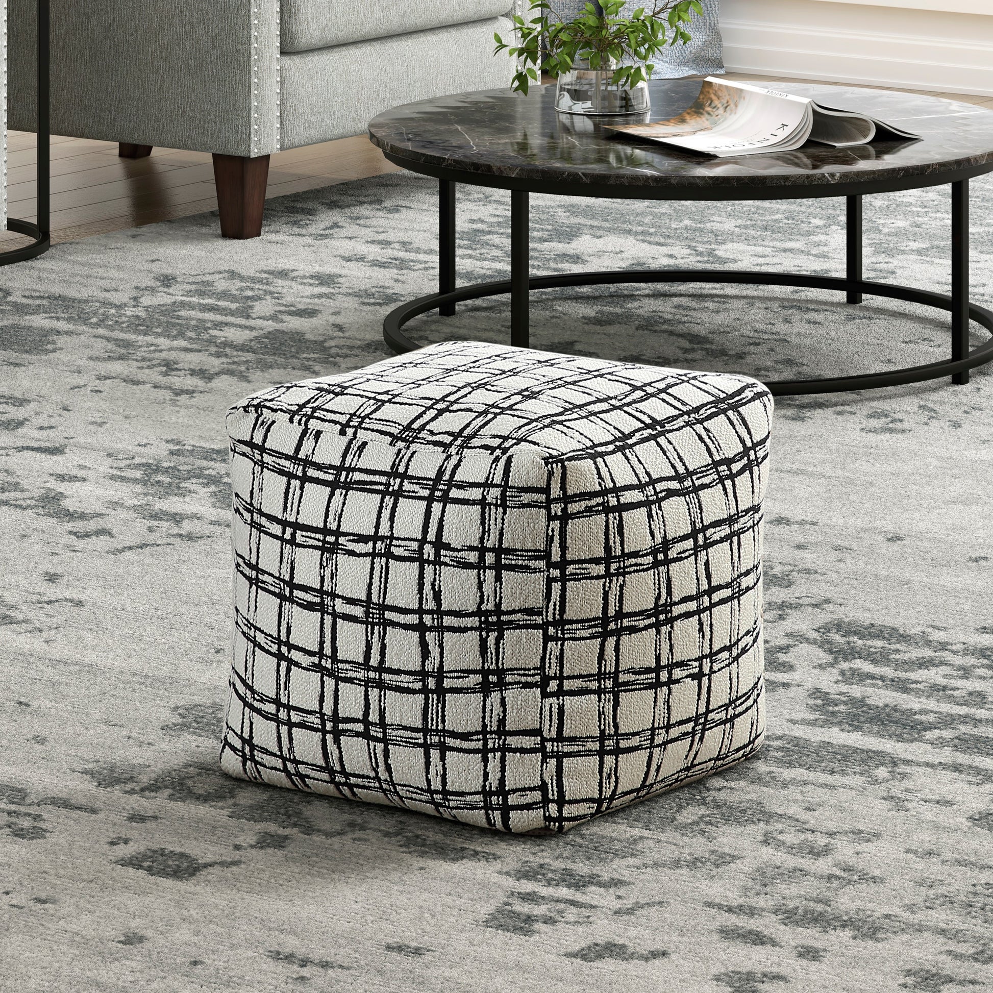 Black and white plaid ottoman with fabric upholstery perfect for living room seating