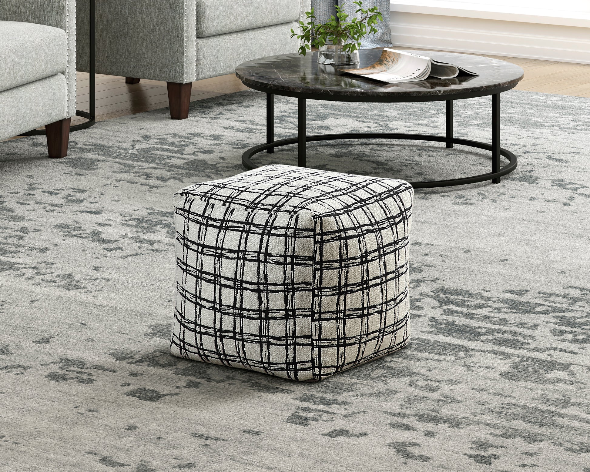 Square ottoman with a textured black and white plaid pattern perfect for modern living rooms