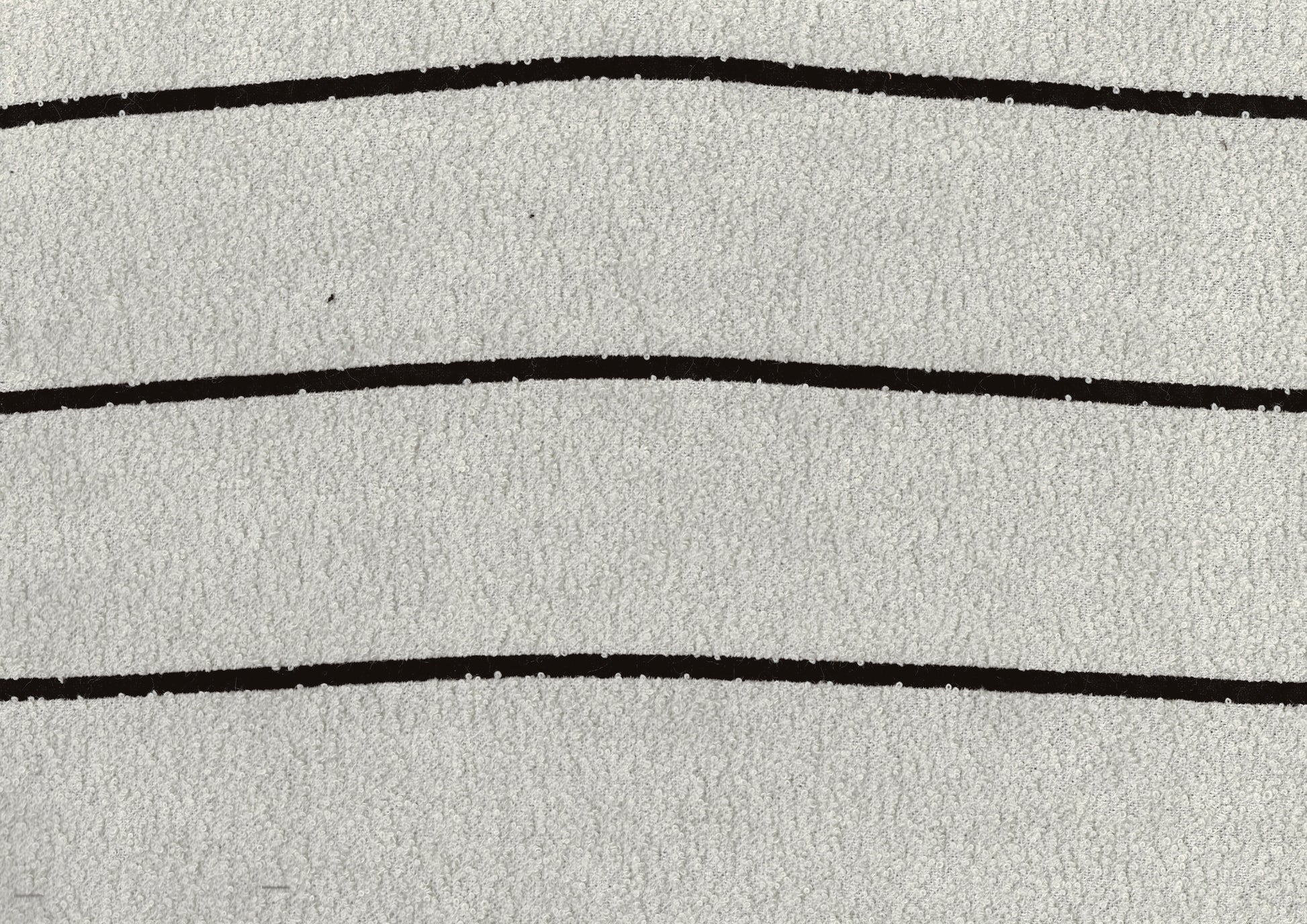 Closeup of fluffy white towel fabric with three thin black horizontal stripes