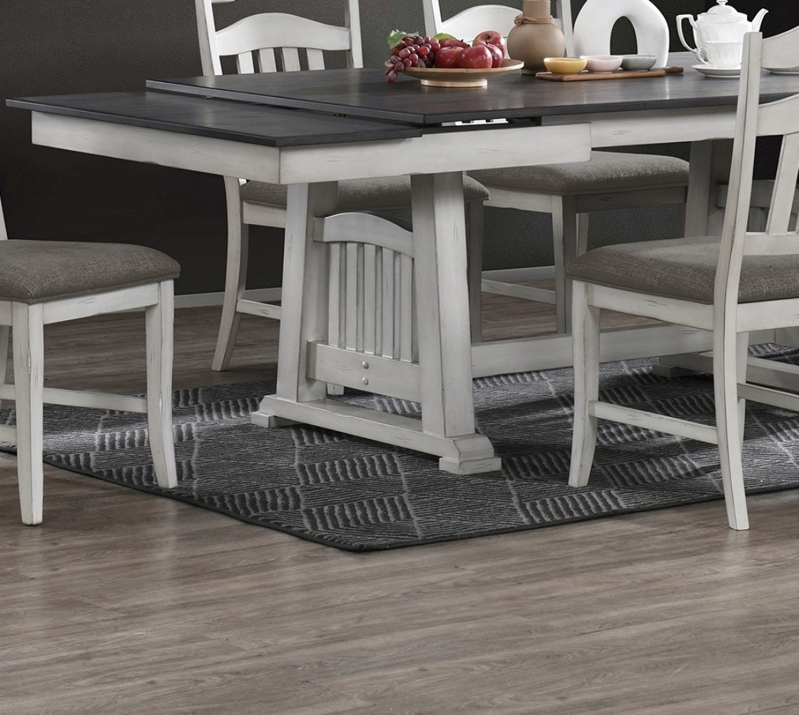 Distressed white wood dining table with dark gray top and upholstered gray chairs farmhouse style
