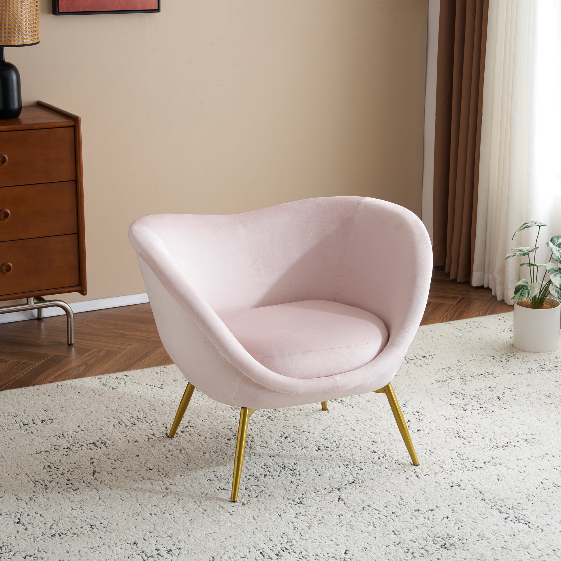 Plush pink velvet accent chair with gold tapered legs perfect for a cozy reading nook