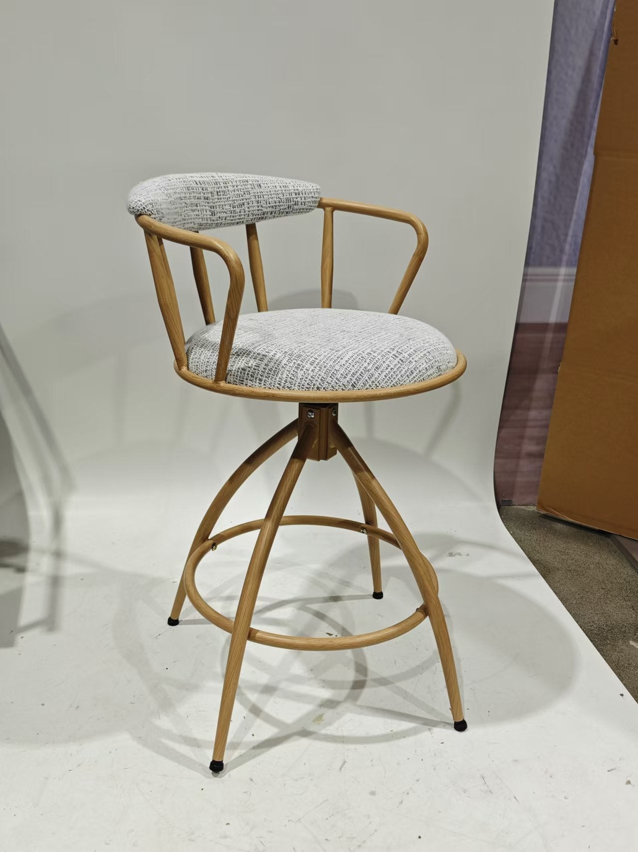 Light oak wood swivel bar stool with a textured grey seat and back