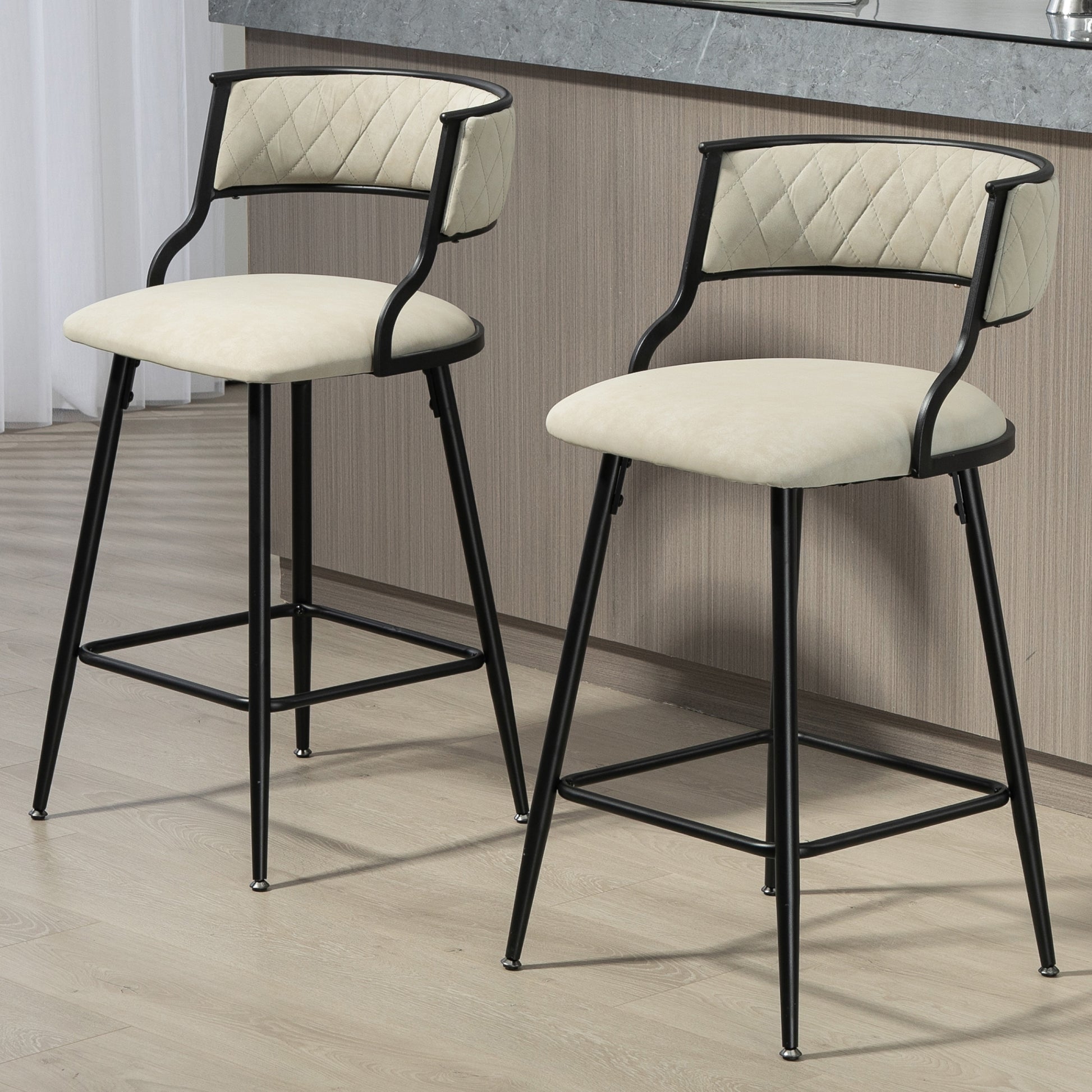 Two cream upholstered bar stools with diamond tufting and black metal legs