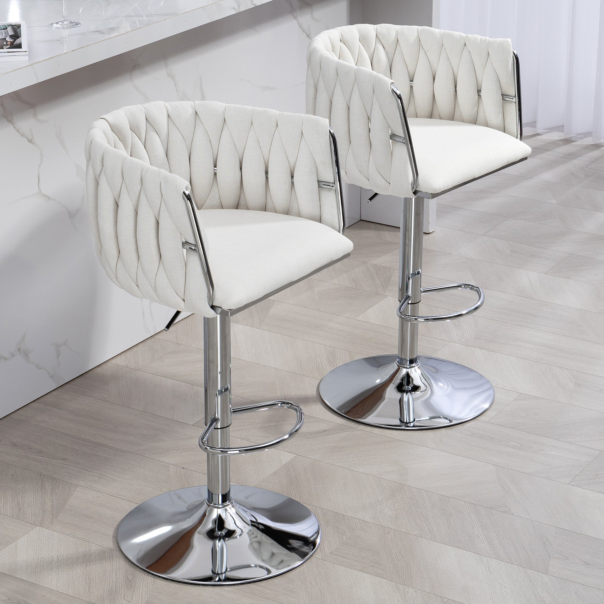 Two white upholstered bar stools with chrome accents and diamond tufting