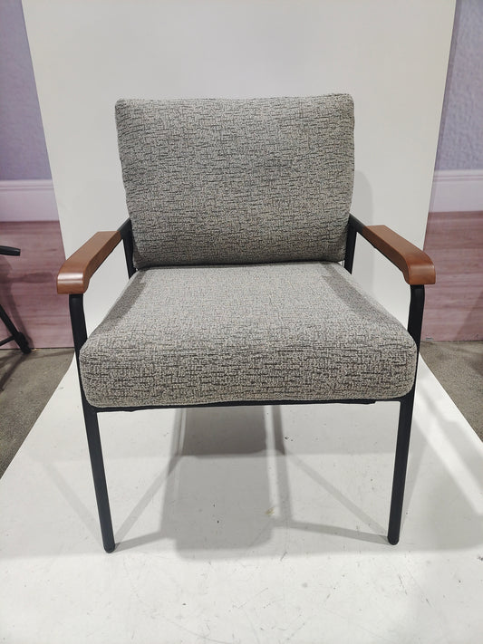 Textured grey upholstered armchair with wooden armrests and black metal legs