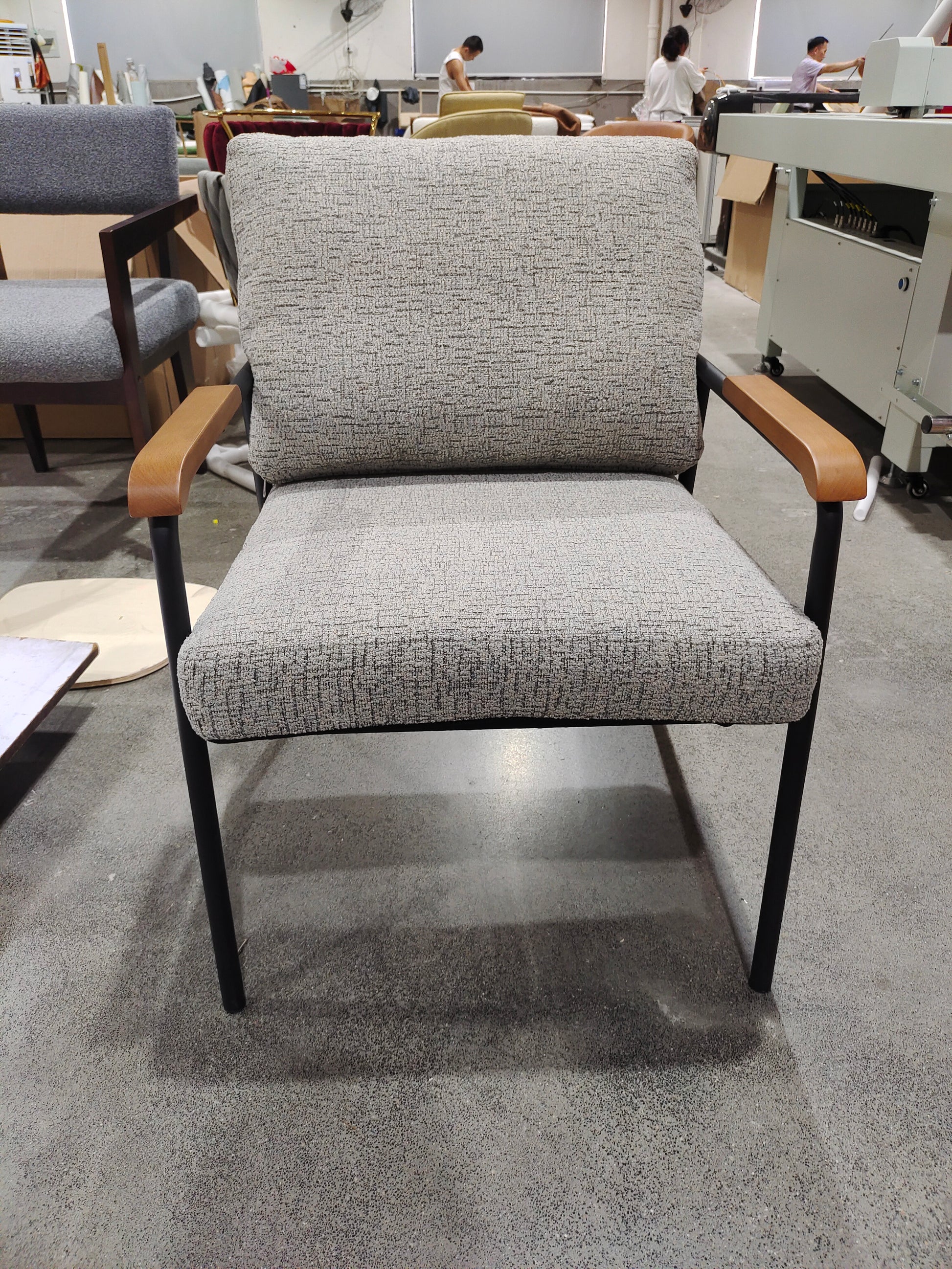 Modern upholstered chair with textured grey fabric and curved wooden armrests
