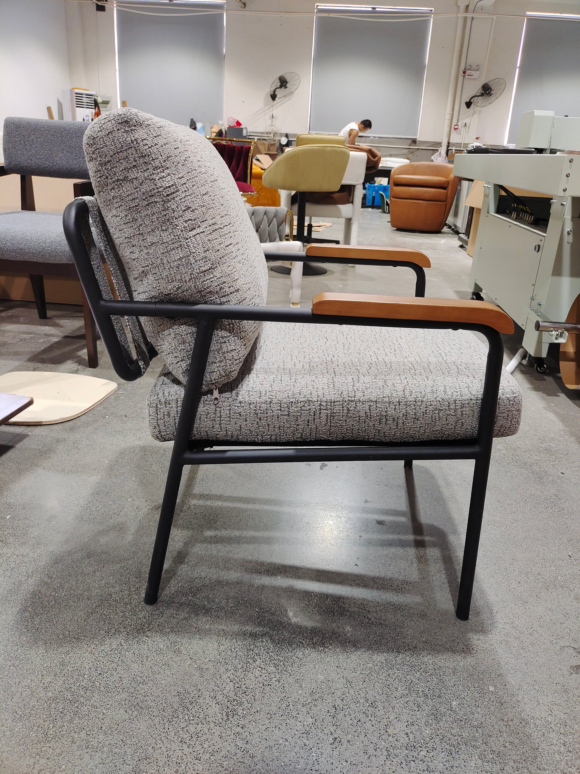 Textured gray armchair with black metal frame and wooden armrests