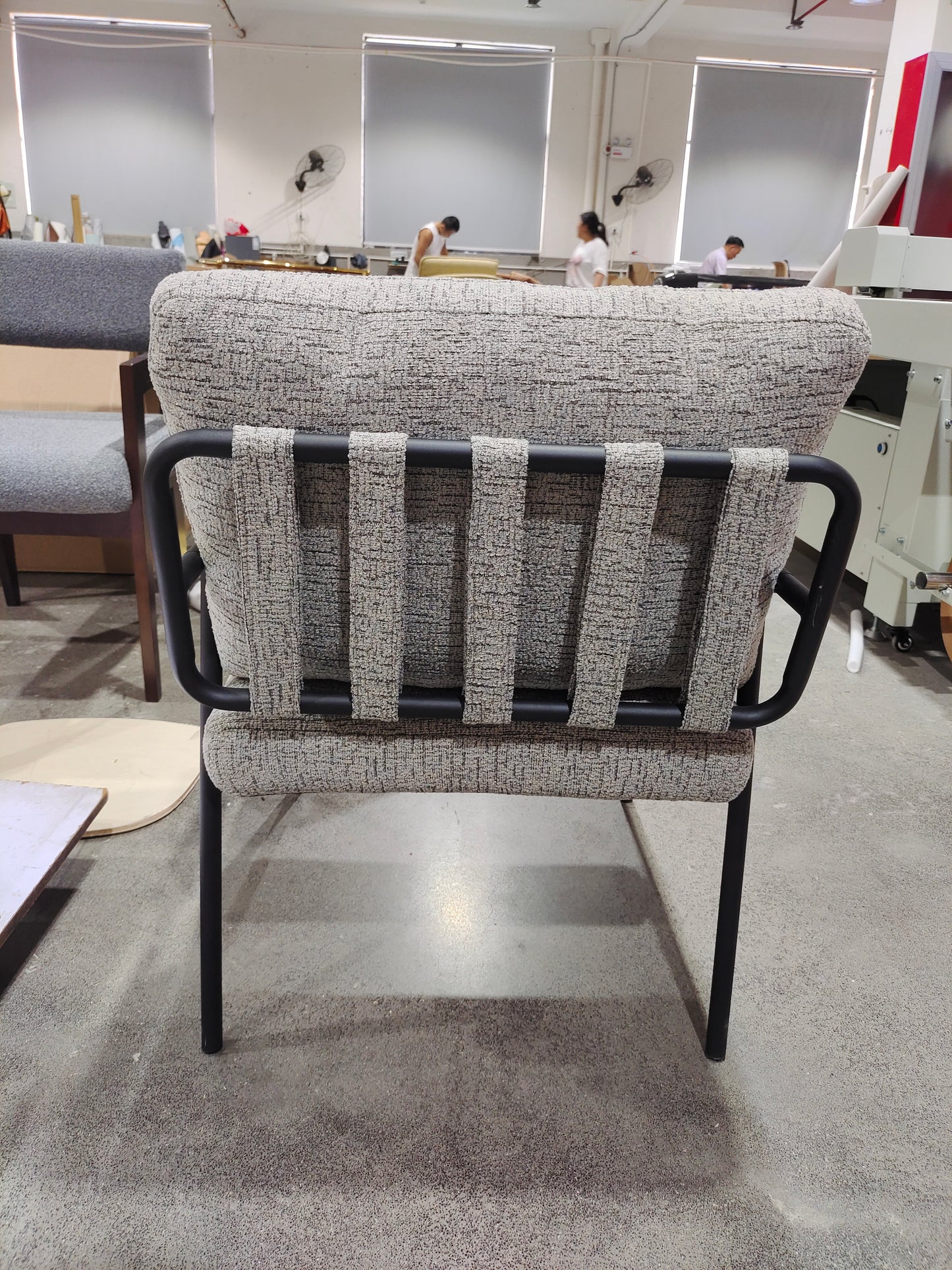 Modern armchair with textured grey fabric and black metal frame