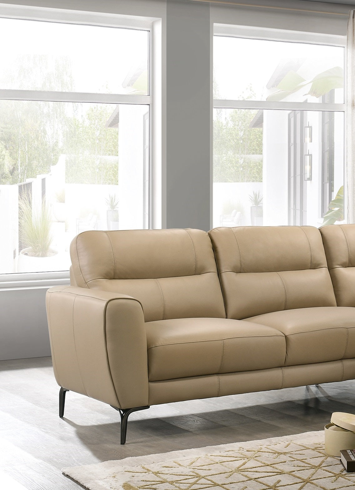 Tan leather sofa with channel tufting and slim black legs perfect for modern living rooms