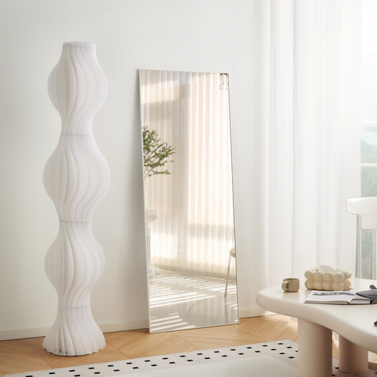 Tall white floor lamp with sculptural wavy panels in a modern design