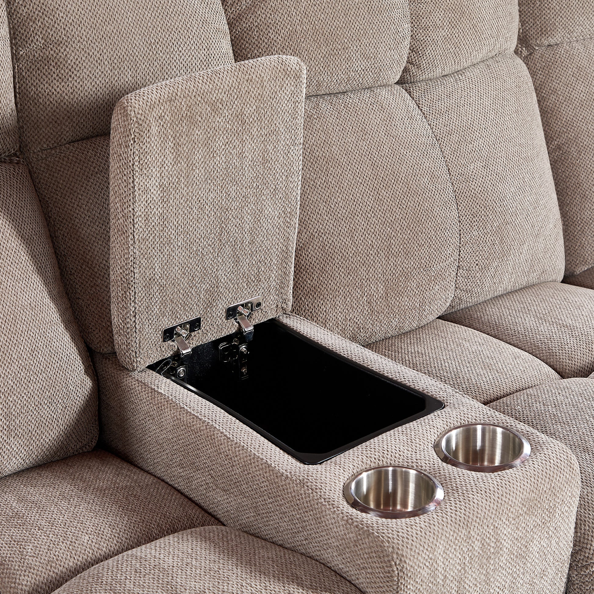 Closeup of a beige recliner sofa armrest with an open storage compartment and two stainless steel cup holders