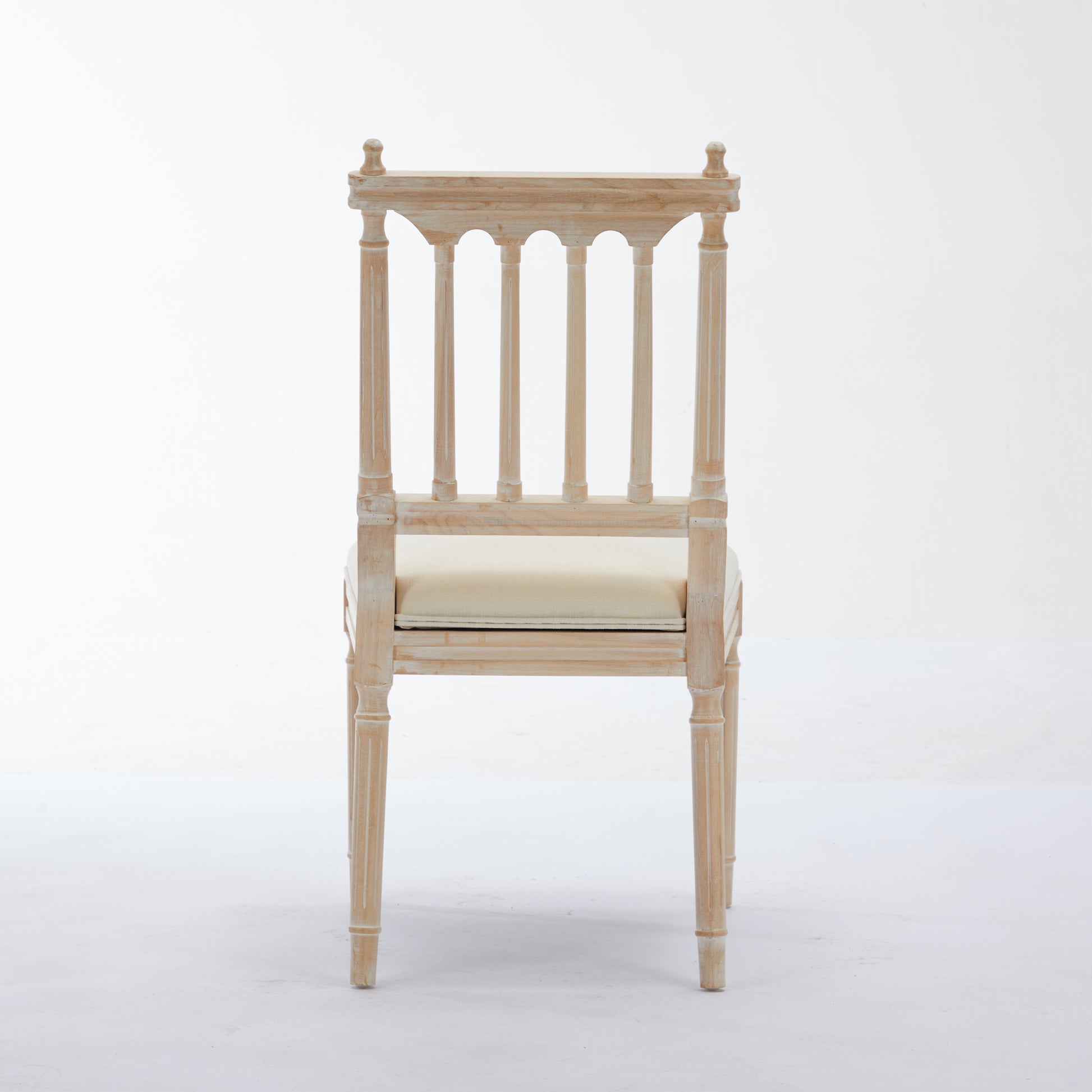Distressed wood dining chair with a cane seat and decorative back splats perfect for a farmhouse aesthetic