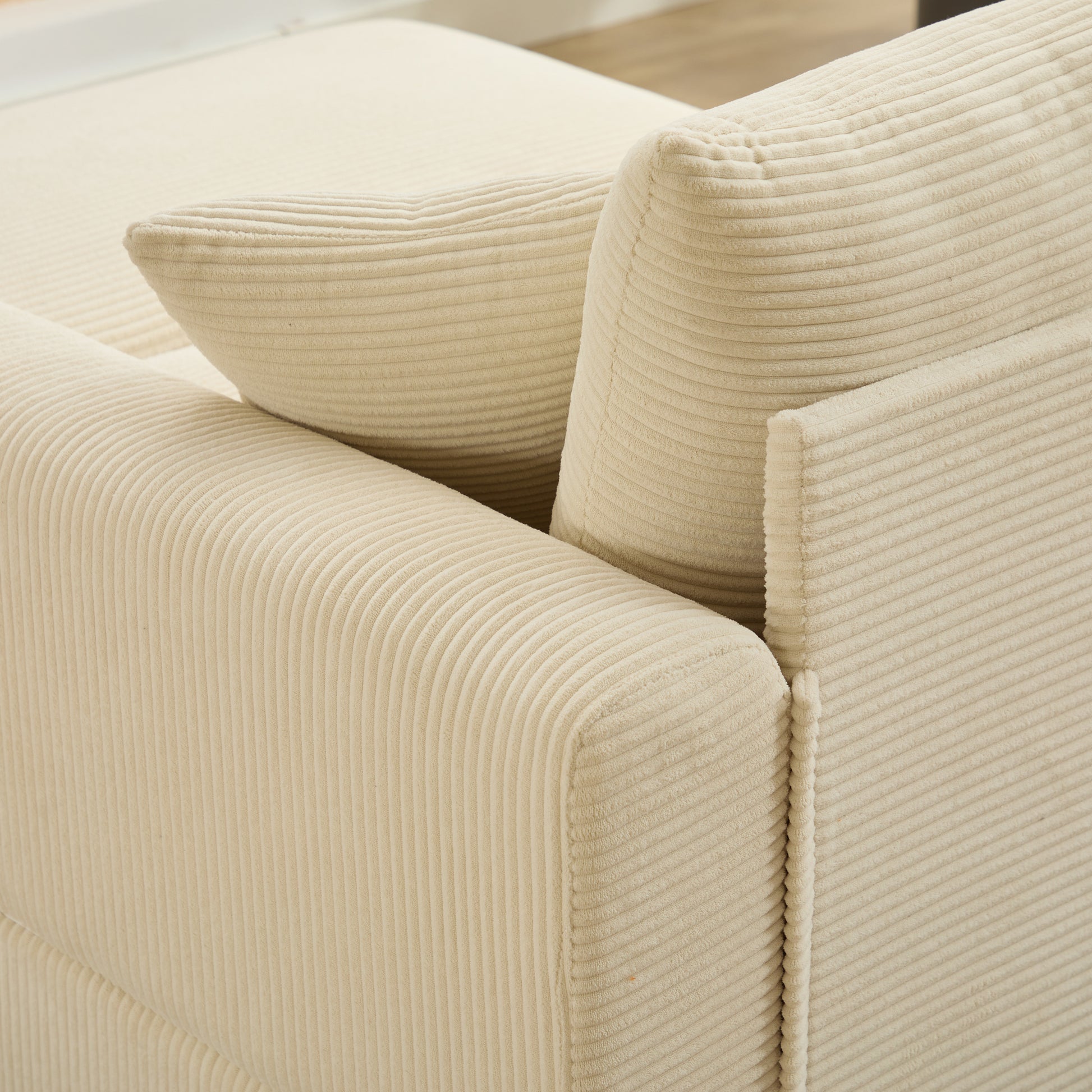 Cream corduroy sofa detail showing plush texture and rounded arms perfect for a cozy living room