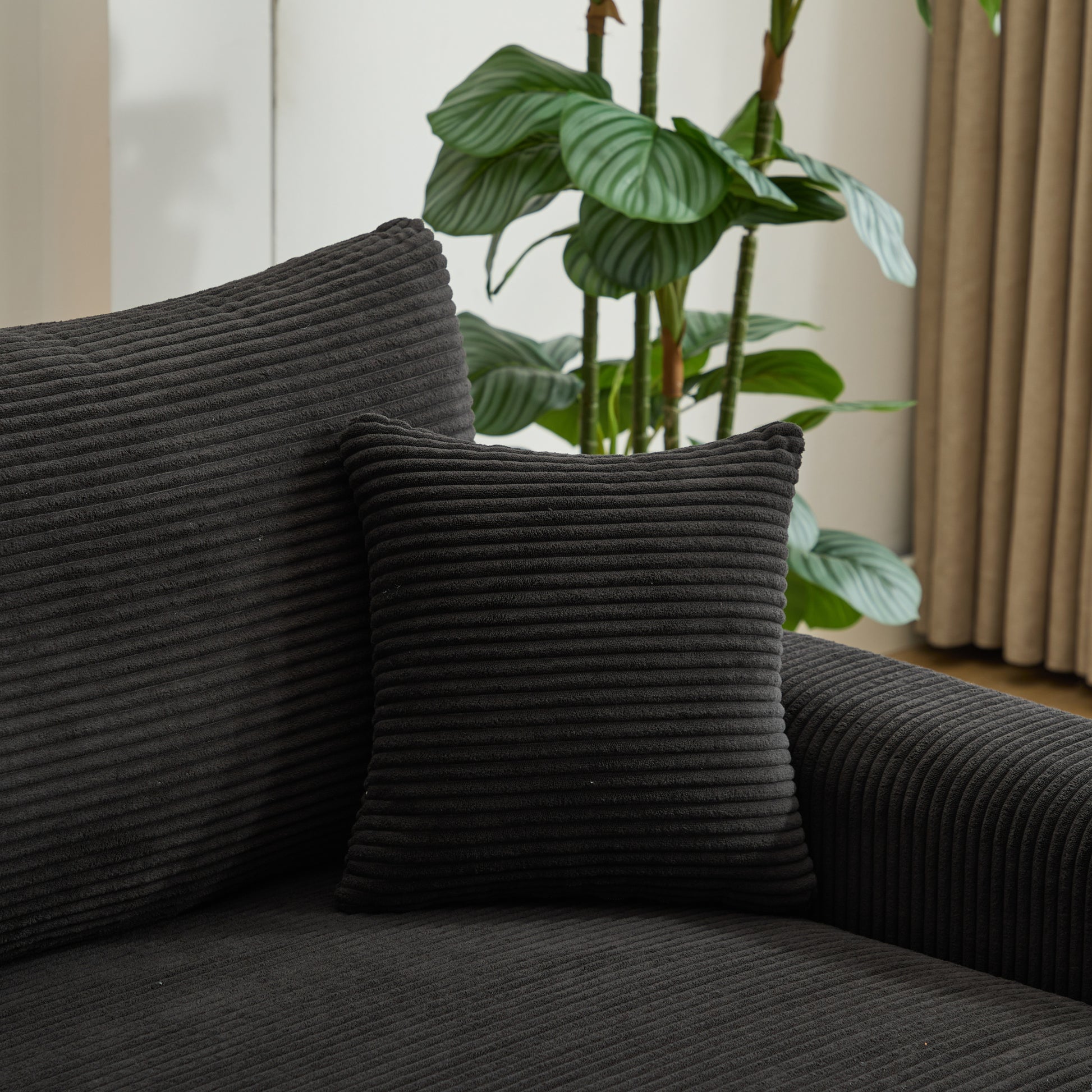 Closeup of a dark gray corduroy accent pillow on a sofa