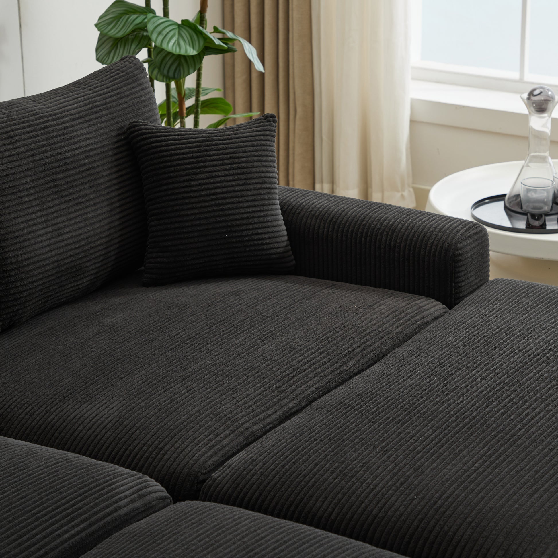 Charcoal corduroy sofa sectional with plush cushions and a decorative pillow