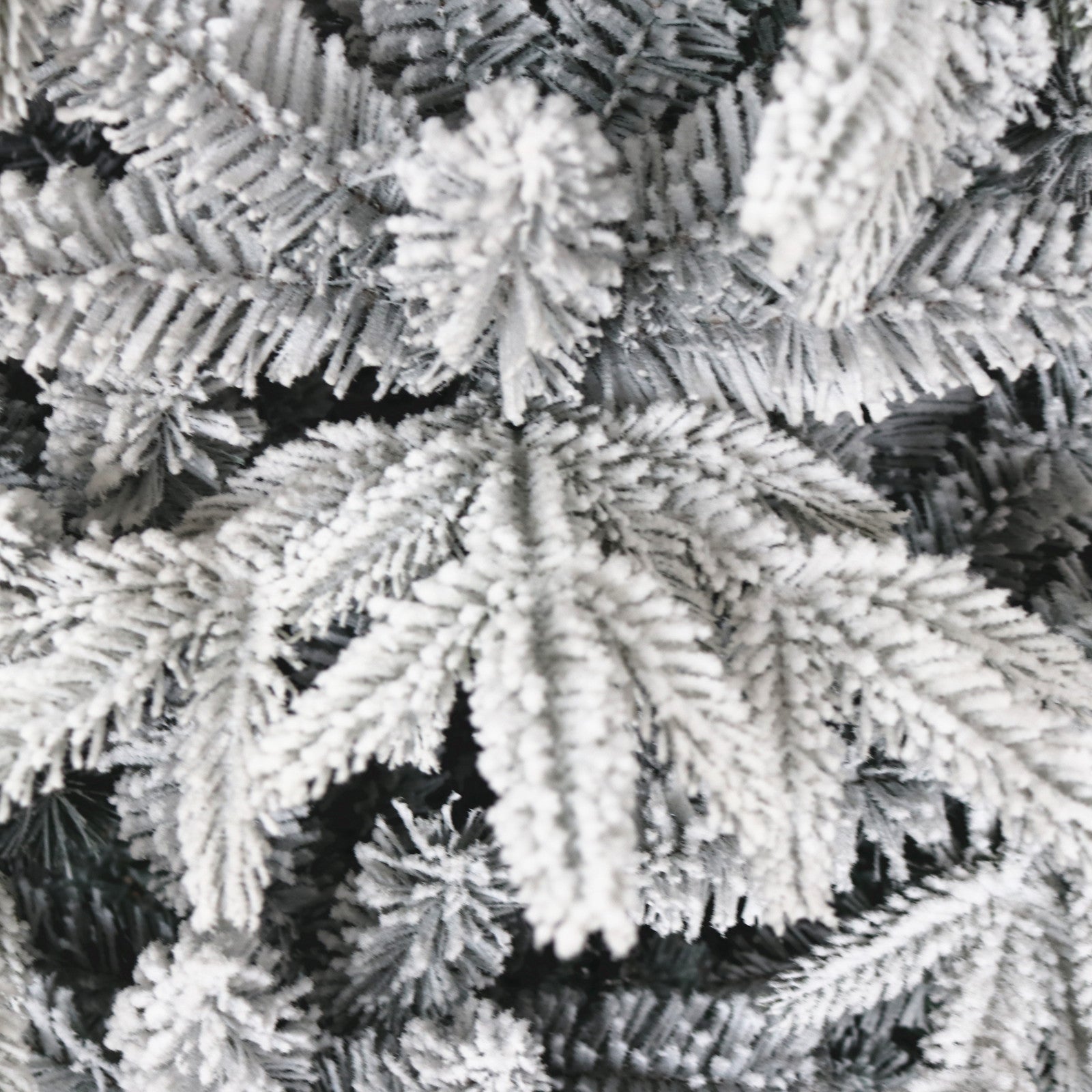 Closeup of flocked artificial pine branches with a winter wonderland effect perfect for holiday decor